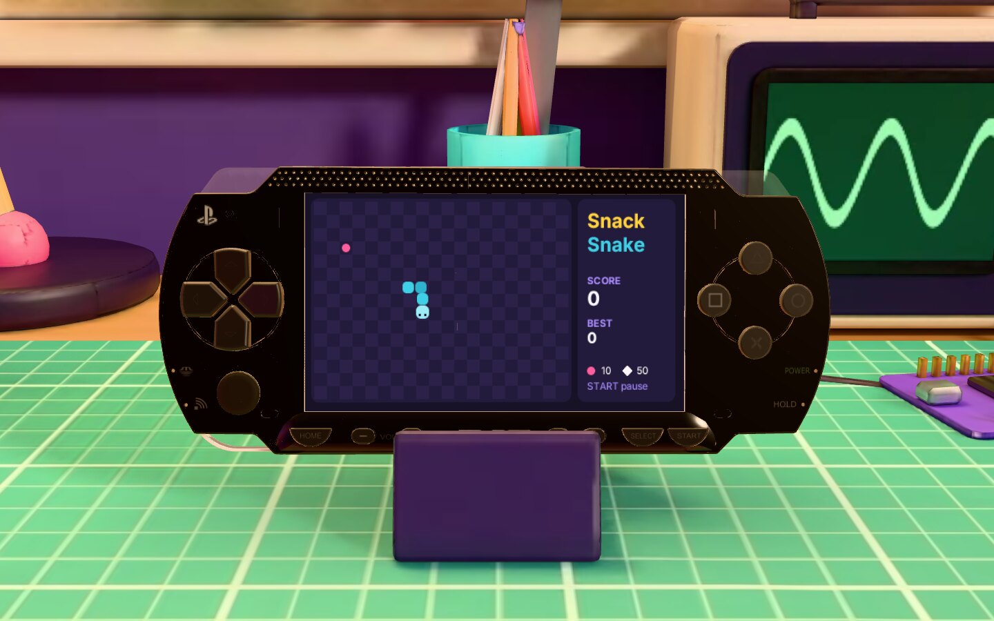A PSP on the workbench running a snake game.